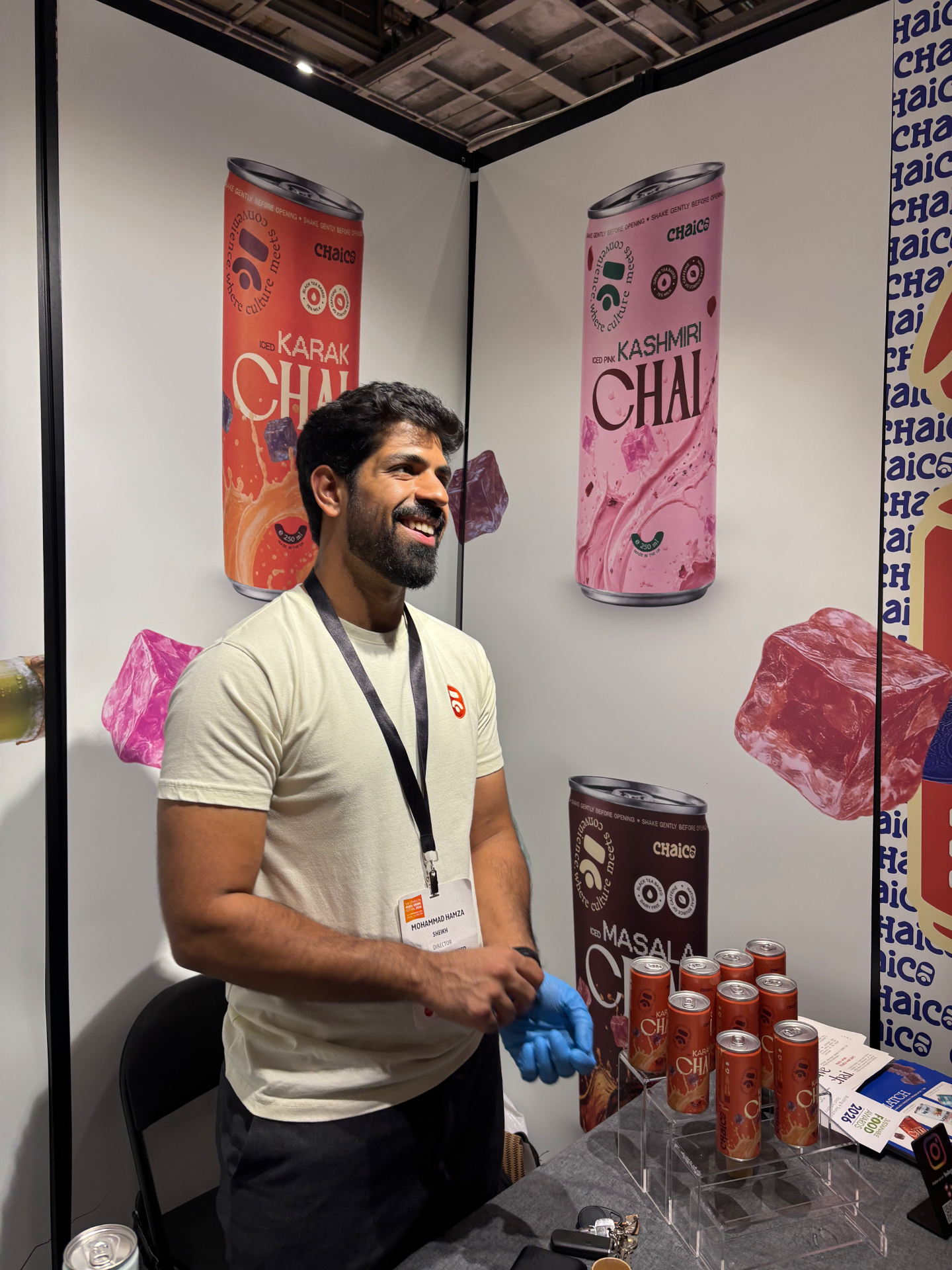 Mohammad Hamza Sheikh on the ChaiCo stand in front of the karak and Kashmiri chai banners